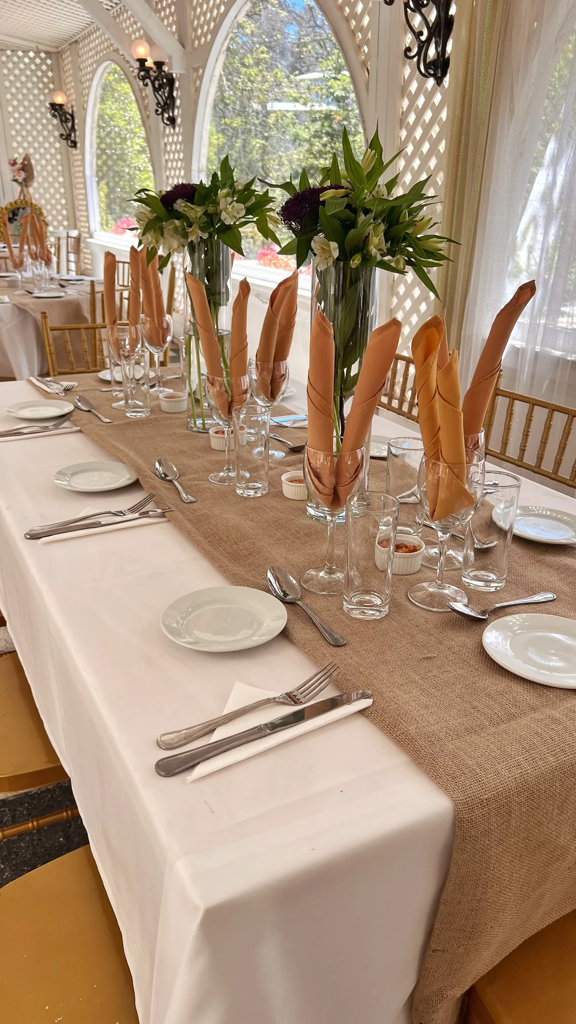 Mesa larga decorada con flores y vajilla