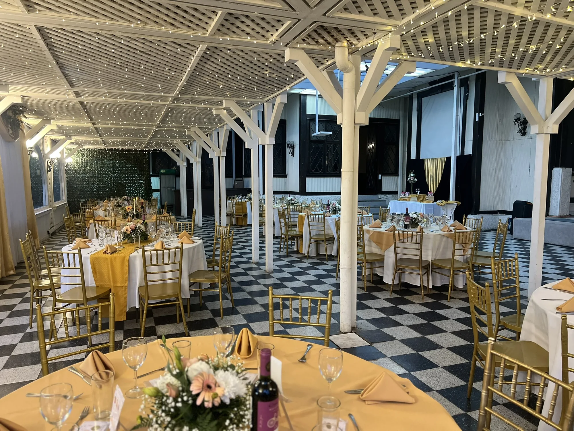 Salón preparado con mesas doradas e iluminación cálida